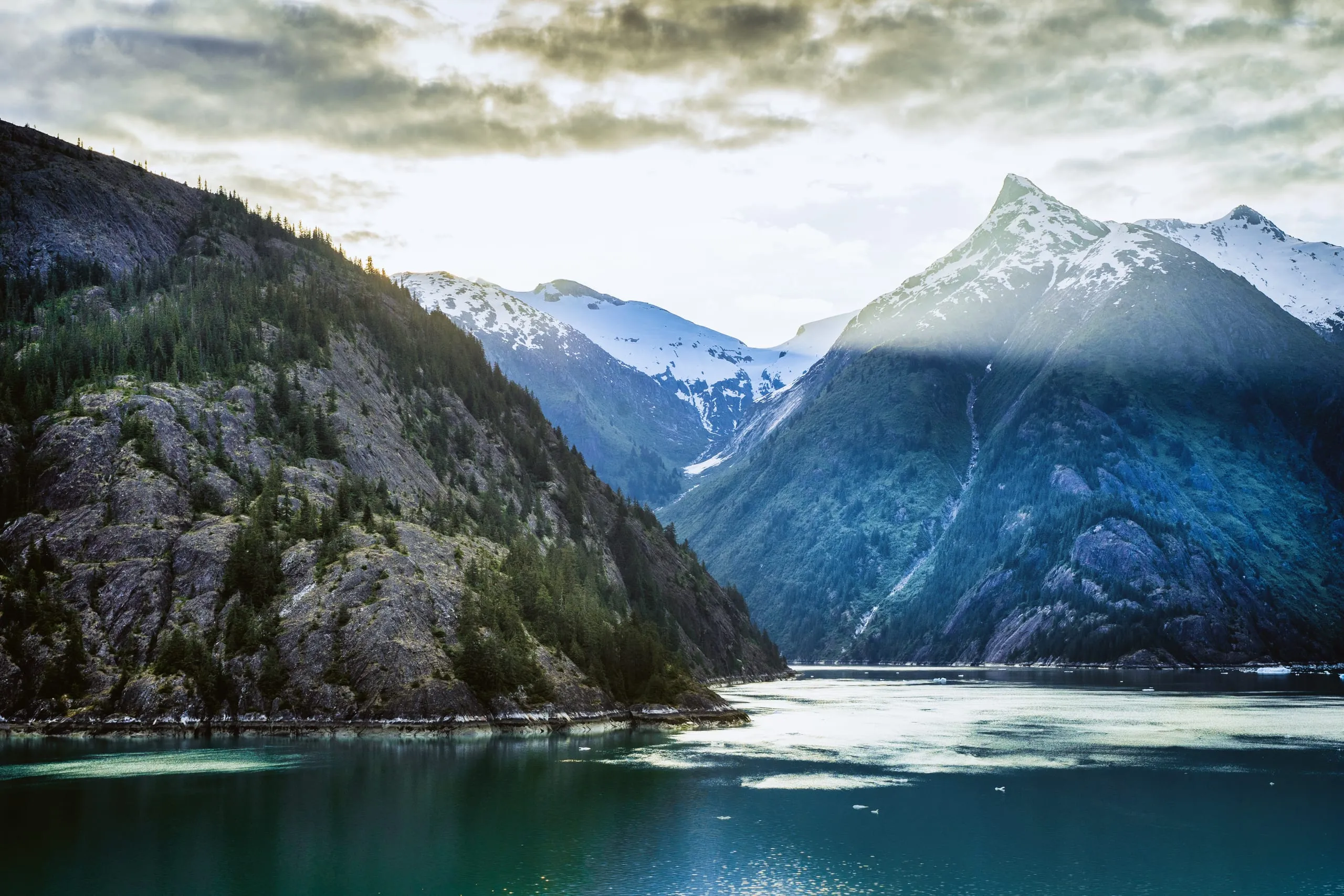 God-rays breaking through cloud over a glacier in Tracy Arm fjord, Alaska